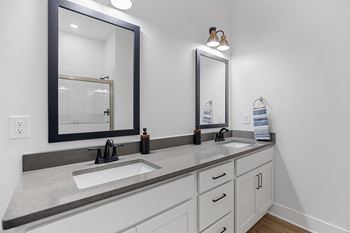 an empty bathroom with two sinks and two mirrorsat Oak Grove at Blake Farm, Wilmington, NC
